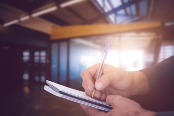 Canvas Print - Composite image of close up of man writing in spiral book