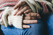© v_sot - Girl's hands in casual wool sweater on her knees on denim jeans. Warmth and comfort concept. Winter mood.