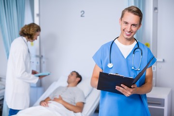 Wall Mural - Portrait of doctor writing on clipboard