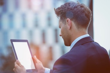 Rear view of businessman using digital tablet