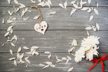 Happy Valentines Day background. Decorative white wooden heart on grey rustic, whith flowers, Valentine's concept.