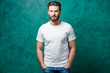 © rh2010 - Man in the white t-shirt with space to copy paste standing on the green wall background.