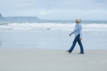 Wall Mural - Senior woman walking on the beach