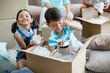 © WavebreakMediaMicro - Kids unpacking carton boxes in living room at new home