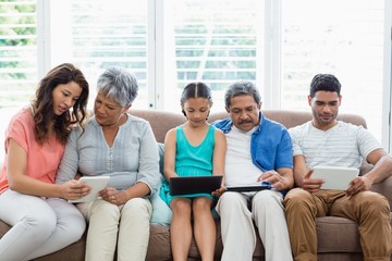 Wall Mural - Multi-generation family using digital tablet in living room