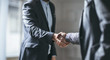© LUMINA IMAGES - Two cropped businessmen handshaking.