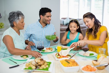 Canvas Print - Happy multi generation family having meal on table