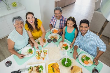 Canvas Print - Happy multi generation family having meal on table at home