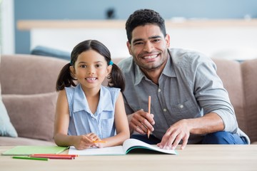 Wall Mural - Father assisting her daughter in doing her homework at home