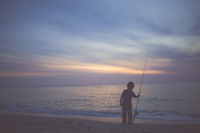 Child Fishing By Sea At Sunset 