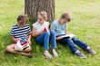 © WavebreakMediaMicro - Kids reading books in park