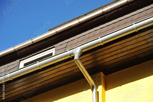 Dachrinne und Regenfallrohr an Gebaeude – kaufen Sie dieses Foto und