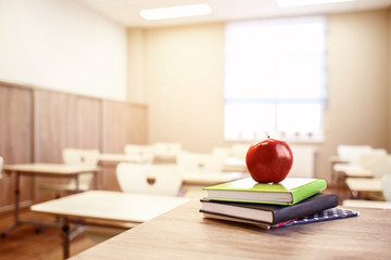 Wall Mural - School teacher's desk with stack of books and apple