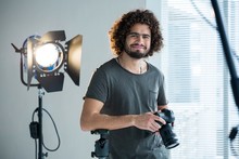 Happy Male Photographer Standing In Studio