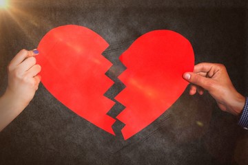 Wall Mural - Composite image of two hands holding broken heart