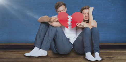 Wall Mural - Composite image of young couple holding broken heart