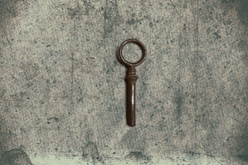 Old key on the old textured paper with natural patterns