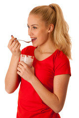 Cute blonde woman eating fruit yogurt isolated over white backgr