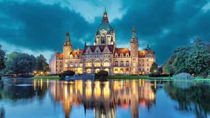 Fototapete - New City Hall of Hannover reflecting in water in the evening  (static image with animated sky)
