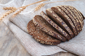 freshly baked bread with ears of rye and wheat on the wooden bac