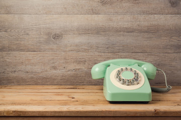 Wall Mural - Retro telephone on wooden table. Call center or support service concept background