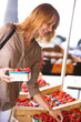 © plprod - femme souriant au marché qui achète des fraises