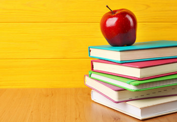 Sticker - Books and apple on wooden background