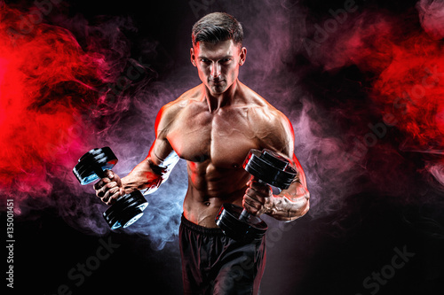 Zdjęcie XXL Przystojny bodybuilder robi ćwiczeniu na bicepsach z dumbbell. Studio strzał. Palić.