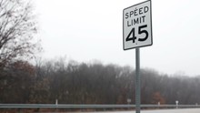 Speed Limit Sign 45 Miles Per Hour On Road With Passing Traffic