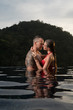 © stryjek - Romantic sensual couple alone in infinity swimming pool over beautiful tropical background