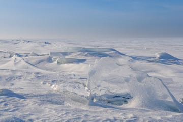 Wall Mural - blocks of ice gleaming in the sun, snow, frost, frozen water surface.