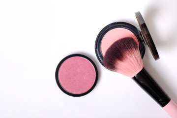 Cosmetic pink blush on and makeup brush.