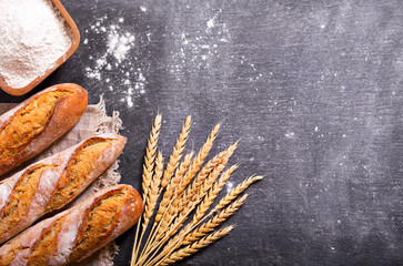 bread with wheat ears and bowl of flour