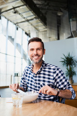 Canvas Print - Smiling man eating alone