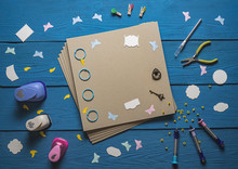 Blank Photo Album And Scrapbooking Tools On Wooden Boards
