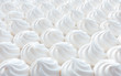 Closeup of white mini meringue swirls as food background.
