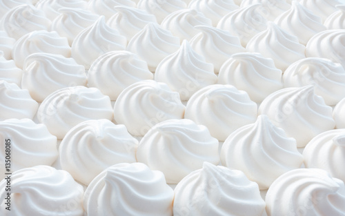 Fotografía Closeup of white mini meringue swirls as food background.