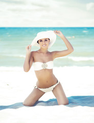 Wall Mural - Young woman in a sexy swimsuit on the beach