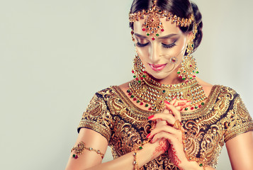 portrait of beautiful indian girl. young hindu woman model with golden kundan jewelry set . traditio