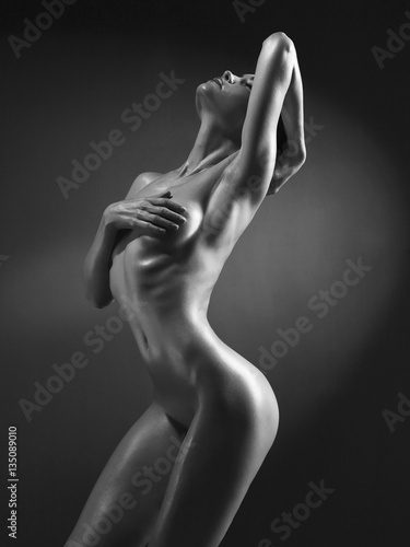 Fototapeta na wymiar Elegant nude model in the light colored spotlights