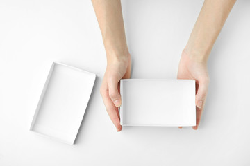 Female hands with open box on white background