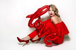 © EkaterinaJurkova - Valentine's Day. Word love letters from the inflatable. Girl holding a big word love.Girl with retro hairstyle in red dress in red high heels sitting on the floor in studio on a white background.