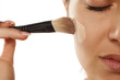 © vladimirfloyd - A young woman applied liquid foundation on her face with a brush