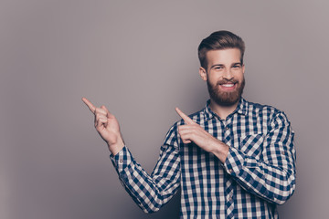 Wall Mural - Happy young man pointing with fingers on copy space