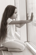 © Africa Studio - Little sad girl sitting on windowsill