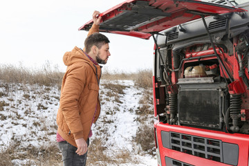 Wall Mural - Handsome driver near truck with open hood outdoors