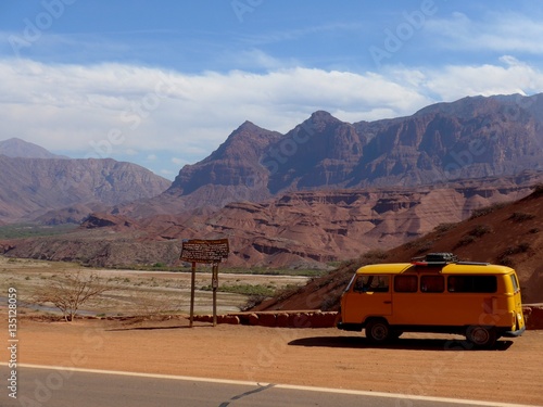 Yellow Kombi parked in front of red dry valley on the way to Cafayate in Nth Argentina Poster
