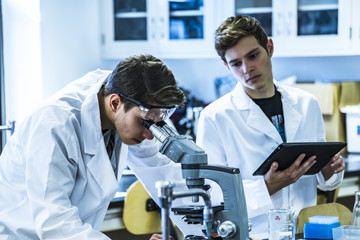 Coronavirus. Two young male scientist working on science research in laboratory. lab reserach of two man. Laboratory researchers