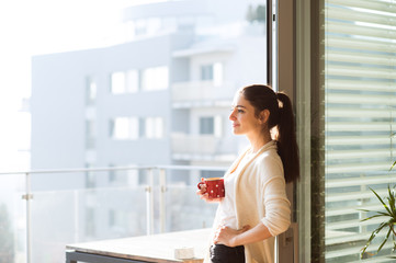 Wall Mural - Woman relaxing on balcony holding cup of coffee or tea