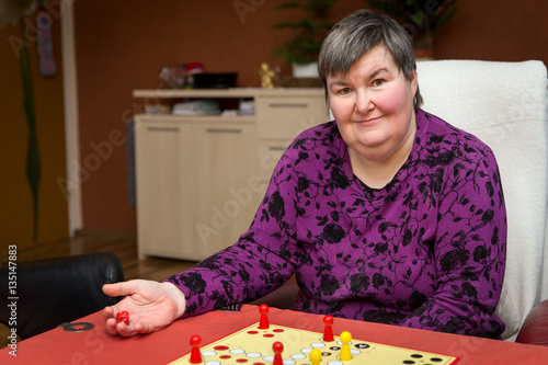 Foto geistig behinderte Frau spielt ein Brettspiel, Alternative Thera